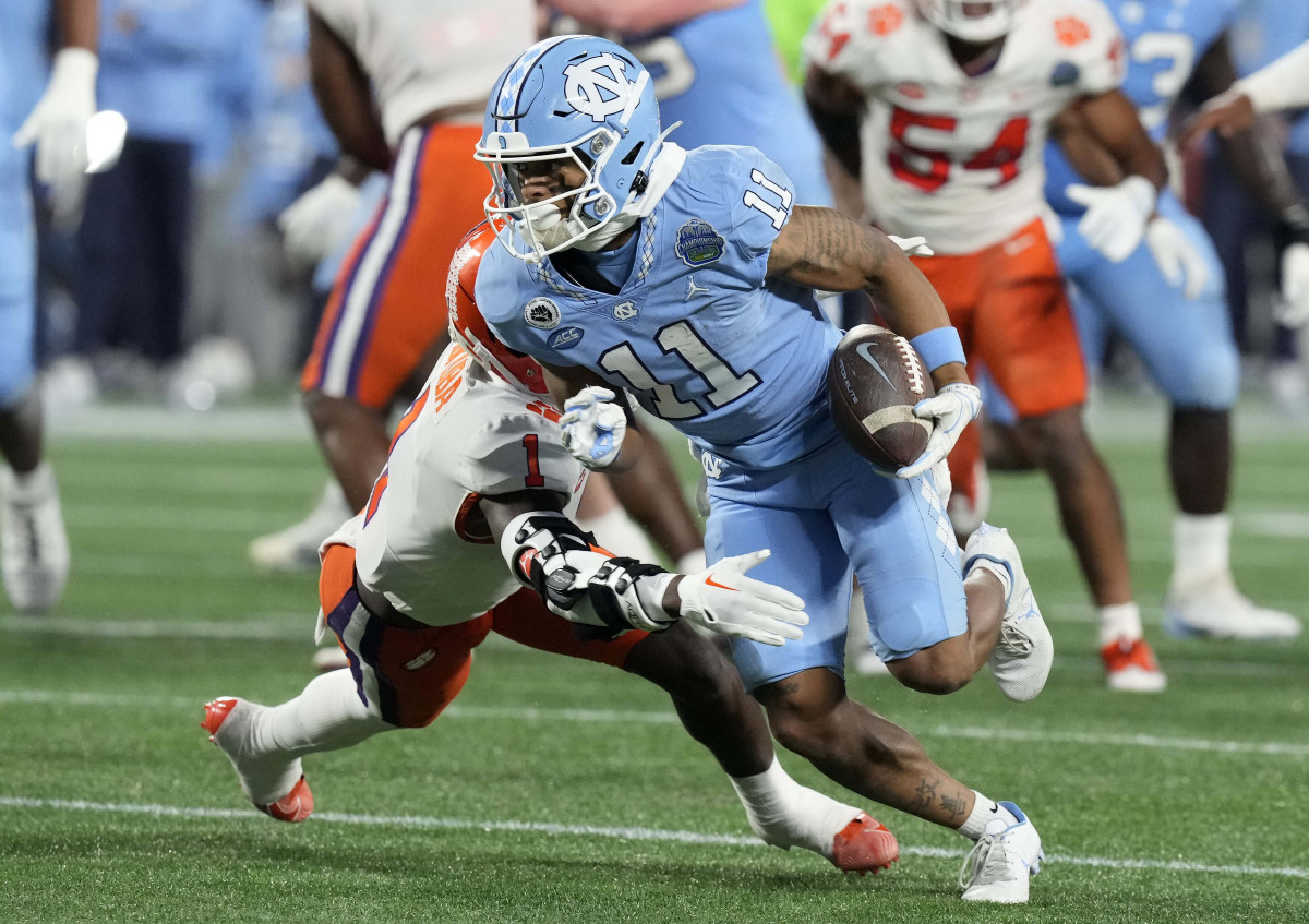 Dec 3, 2022; Charlotte, North Carolina, USA; North Carolina Tar Heels wide receiver Josh Downs (11) runs past Clemson Tigers safety Andrew Mukuba (1) during the first quarter of the ACC Championship game at Bank of America Stadium. Mandatory Credit: Jim Dedmon-USA TODAY Sports